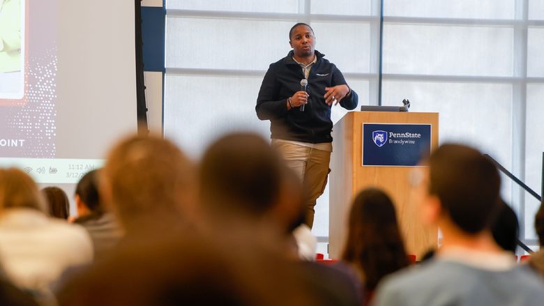 man talking in front of a crowd