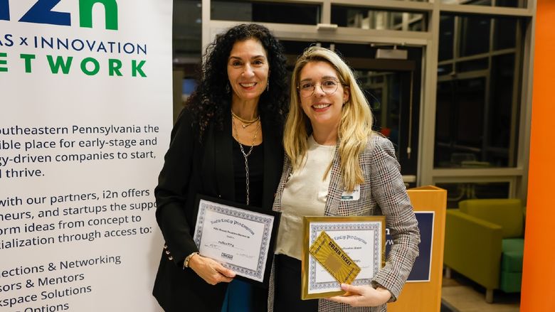 two ladies holding certificates