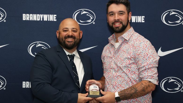 two men holding a baseball