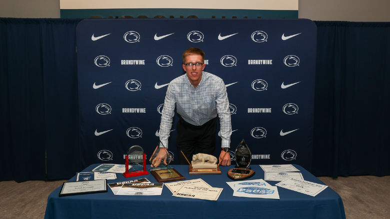 man at a table with awards