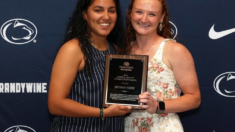 Two women holding a plaque