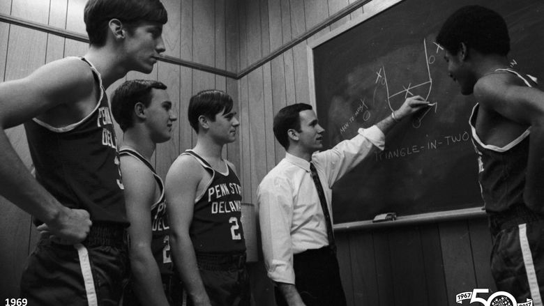 basketball coach working out strategy plays with team