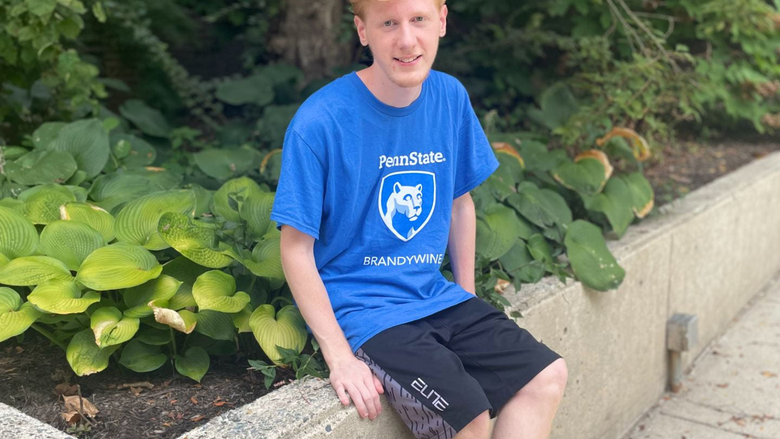 Benjamin Keller sitting next to plants in a Brandywine t-shirt