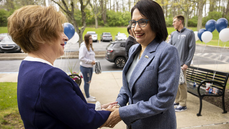 Two women shake hands.