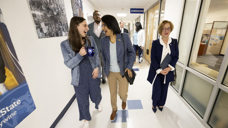 Three women walk down a hallway.
