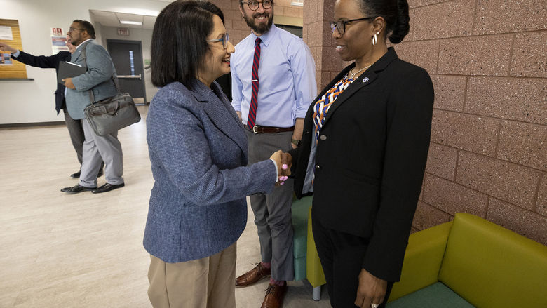 Two women shake hands.