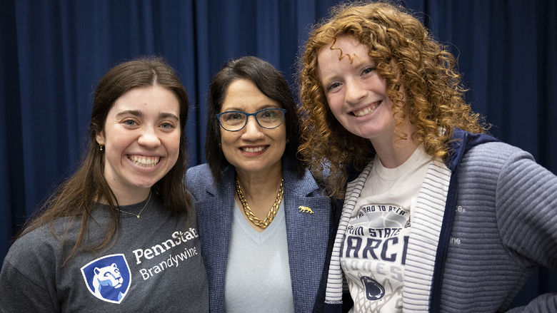 Three women stand together.