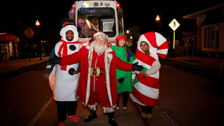 students in snowman, tree and candy cane costumes with Santa