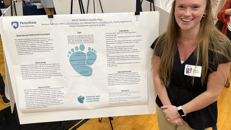 A women stands next to her poster about her internship.