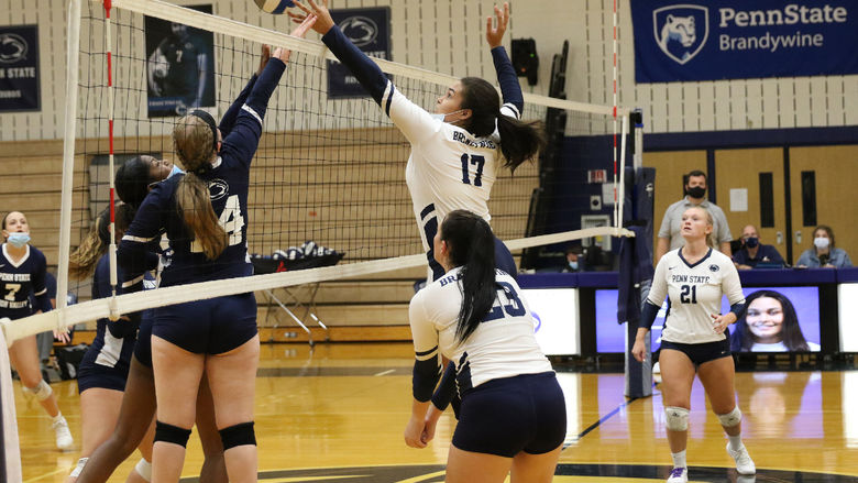 A Penn State Brandywine volleyball hits the ball over the net to earn a point.