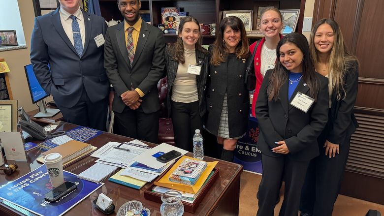 students posing for photo with representative