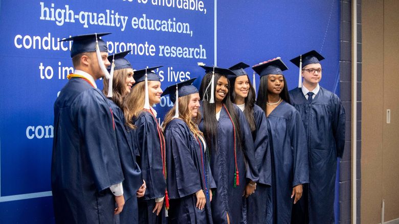 Graduating students posing in the Health and Wellness Building at Penn State Schuylkill