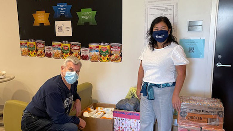 man and woman in masks with donated food