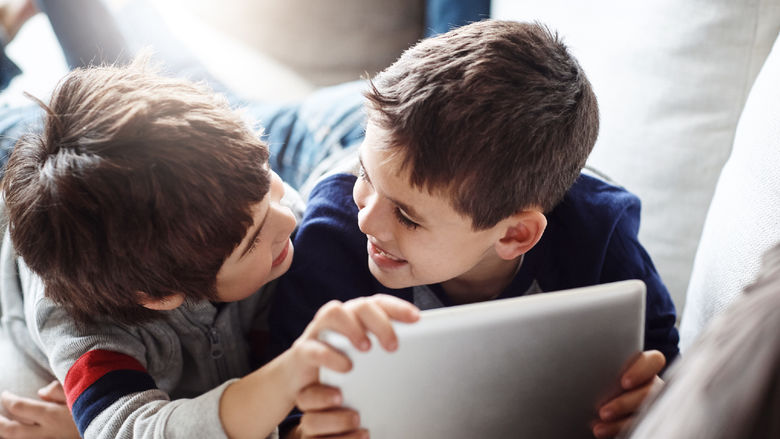 Two children playing on a digital tablet together
