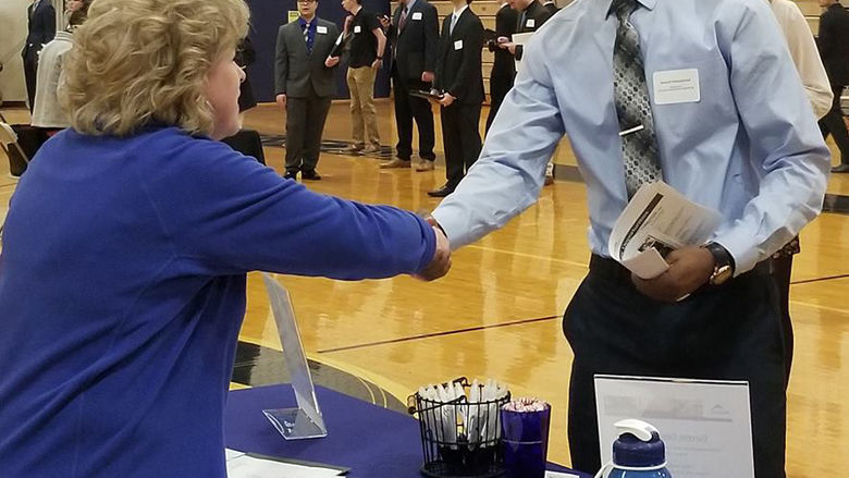 Student shaking hands with a recruiter.
