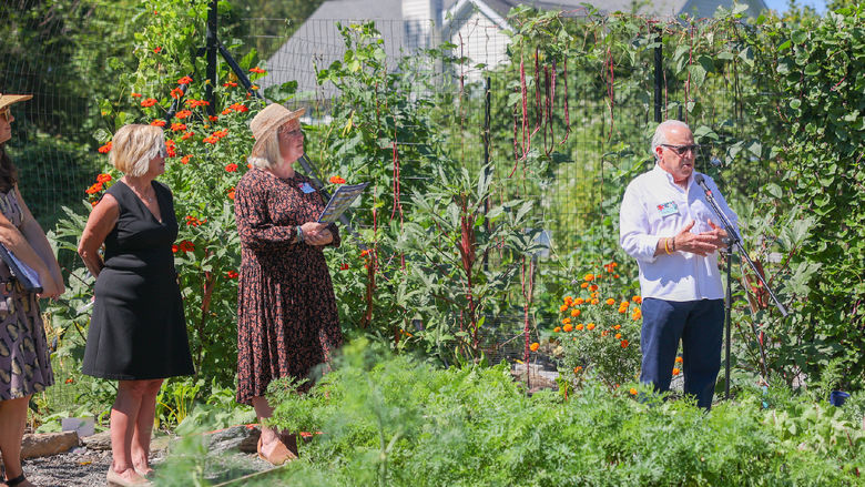 man speaking at microphone in garden