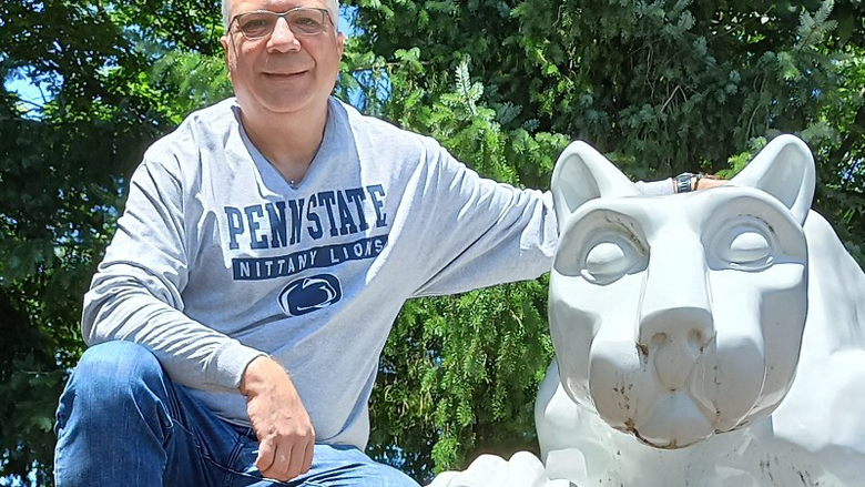 George Eleftherakis posing next to the Penn State Nittany Lion shrine