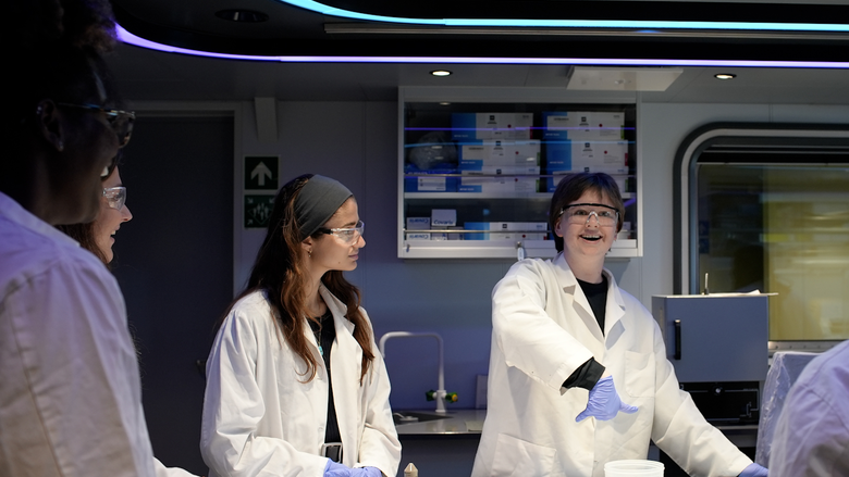 Gracie pointing at experiment on OceanX voyage