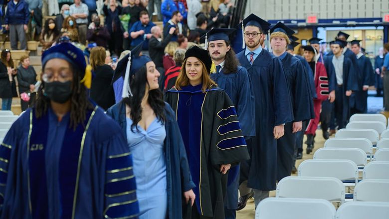 Students and professors walk into the campus gym.