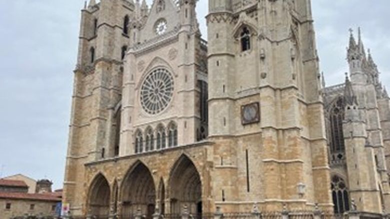 A large Spanish church with an art installation that says "LEON" in front of it