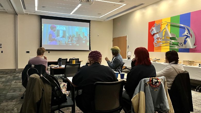 Students sitting at tables watching the film "Till"
