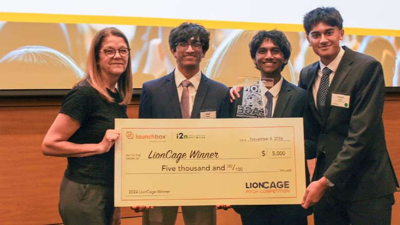 three men and a woman holding a large check