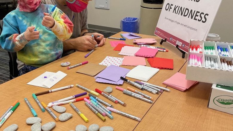 A father and daughter decorate rocks of kindness