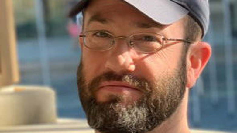 James Berkey smiling and wearing a Penn State Brandywine hat.