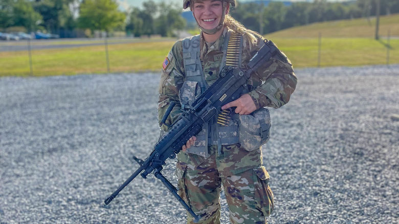 A female soldier holds a rifle.