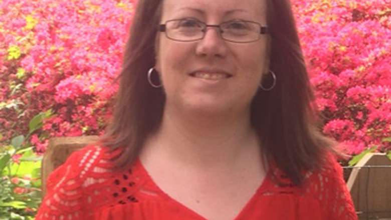 Lauren Jerla smiling in front of flowers