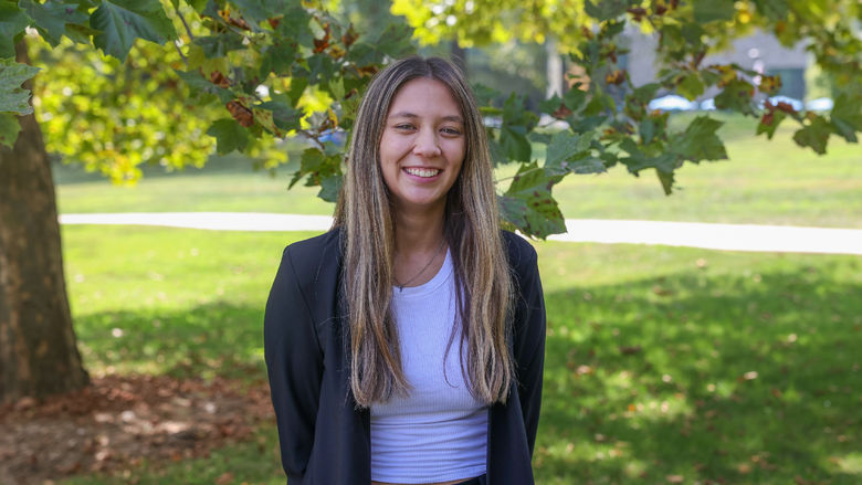 Madison Ollis standing in front of tree