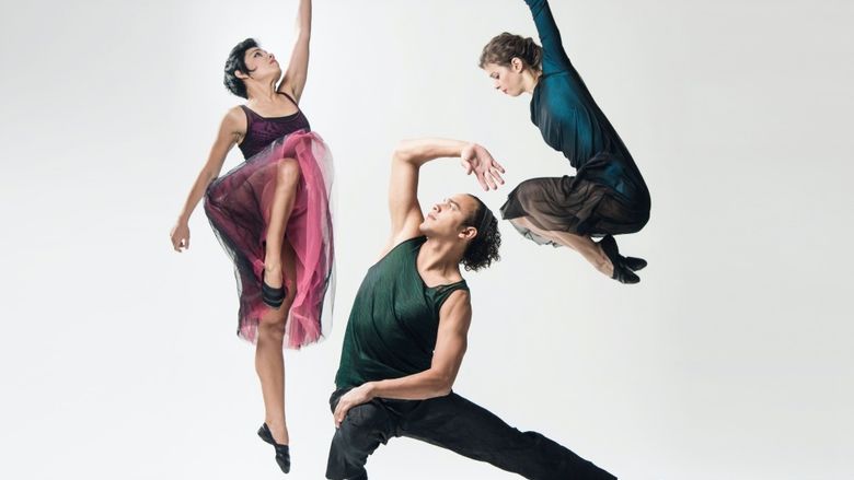 Two dancers in pose in mid-air bookend a grounded dancer in a lunge pose.