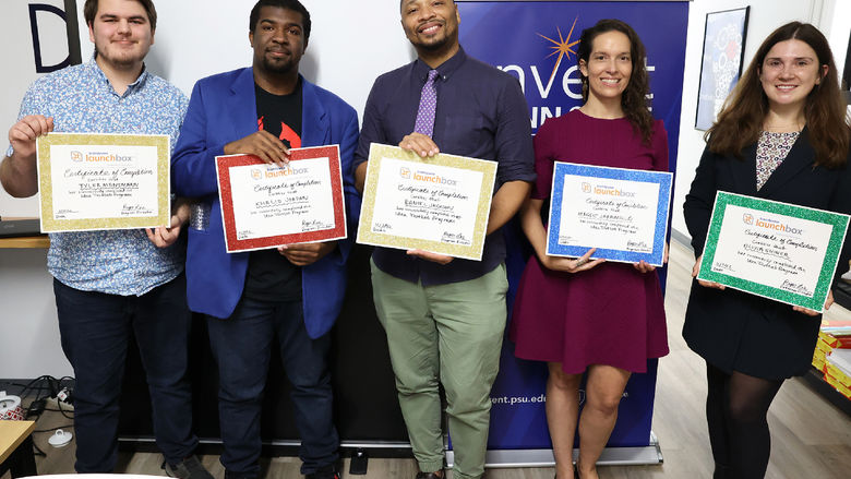 Five people stand holding their participation certificates.