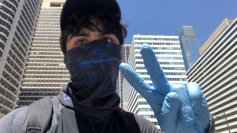 Jacob Mejias wearing a mask and gloves as he films in Philadelphia