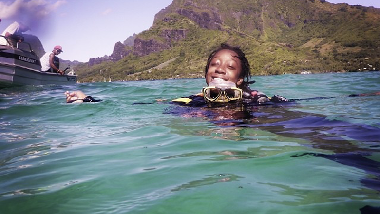 Camille smiling in the ocean wearing scuba gear