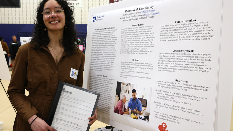 Student standing in front of a poster board