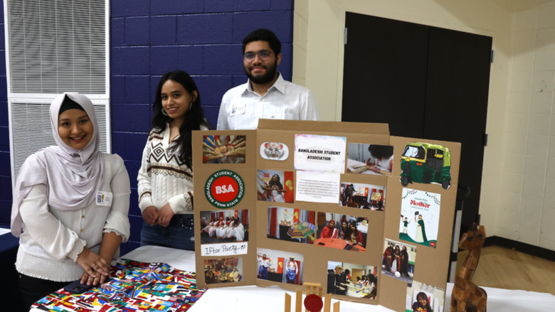 Students standing behind Bangladeshi Student Association poster