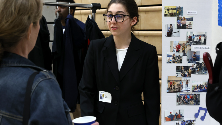 Student explaining poster to employee