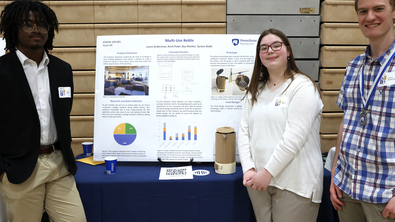 Three students presenting research on a poster