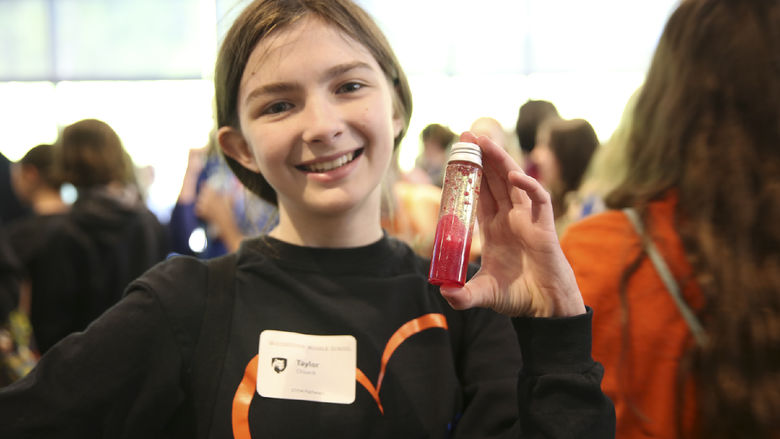 A girl holds a test tube.