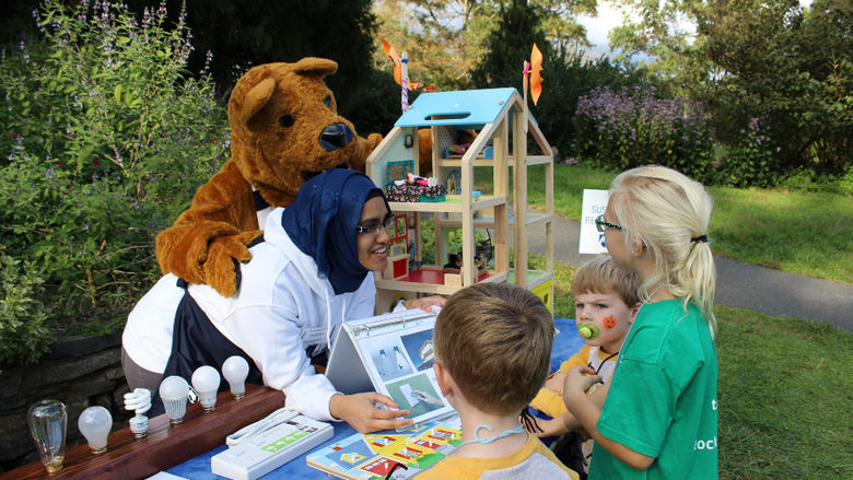 Student and Lion mascot teaching children.