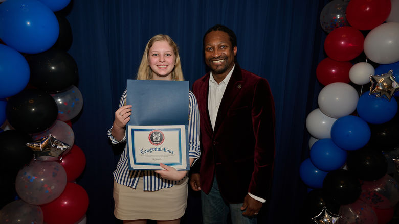 woman holding certificate and standing next to man