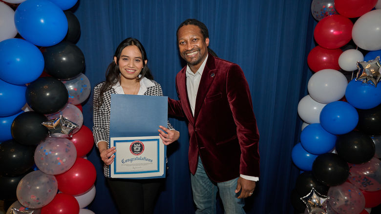 woman holding certificate and standing next to man