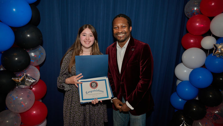 woman holding certificate and standing next to man