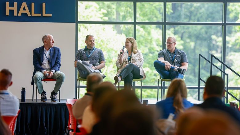 people sitting on a panel on stage