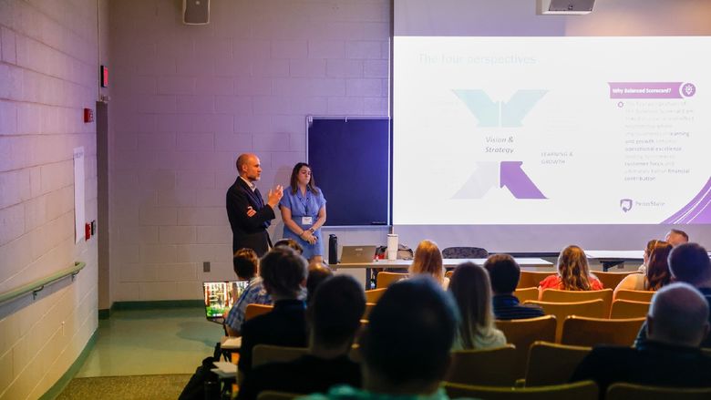 people speaking in auditorium in front of a crowd
