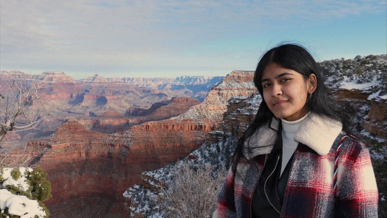 A female stands at the rim of the Grand Canyon.