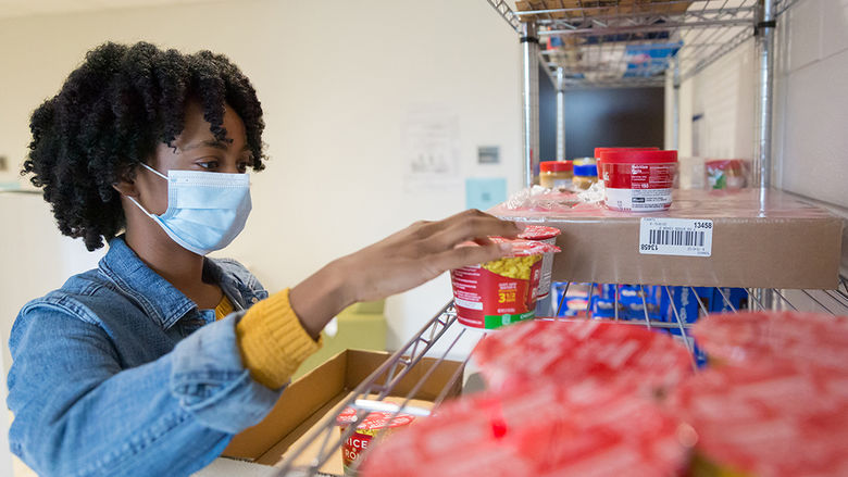 Angel Asomugha stocks Penn State Brandywine's food pantry.