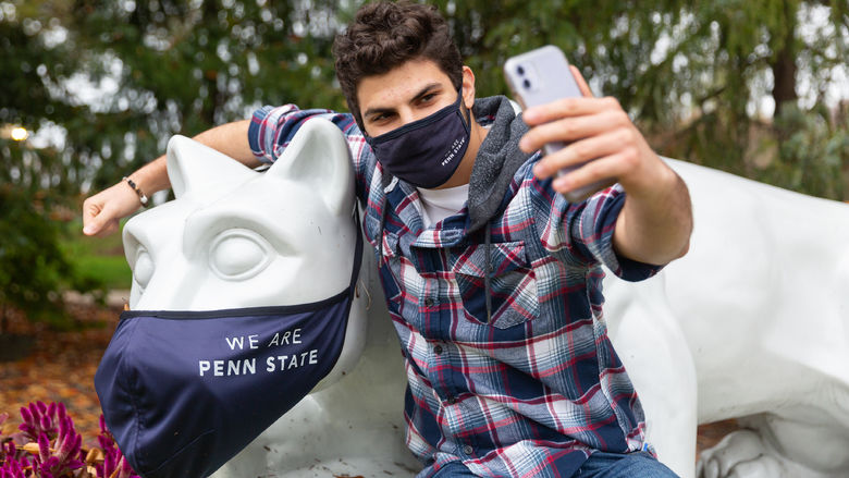 Brandywine student taking a photo with the Lion Shrine.