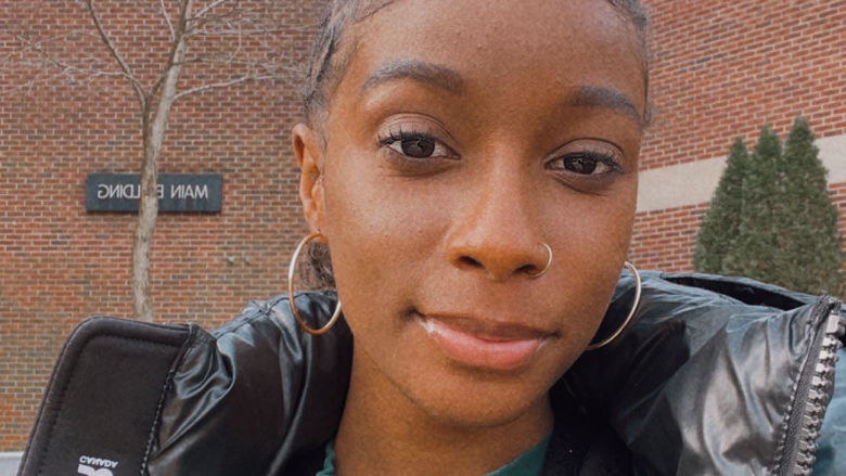 Zhane smiling in front of the Main Building at Brandywine